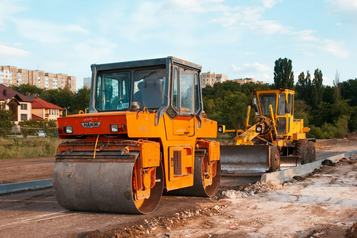 Compaction rollers on an unpaved site surface