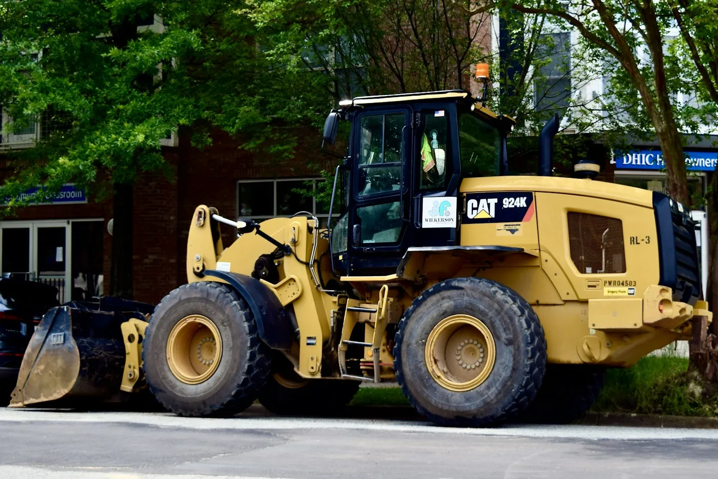 Wheel loader parked beside wooded ground
